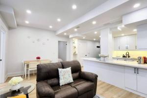a living room with a couch and a kitchen at Serene High-celling Retreat in Oakville