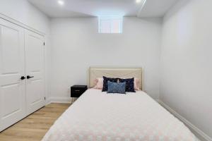 a bedroom with a large bed with pink and blue pillows at Serene High-celling Retreat in Oakville