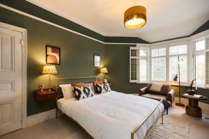 1 dormitorio con 1 cama grande y 1 silla en The Cranley Gardens Escape - Spacious 2BDR Flat, en Palmers Green