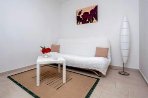 un soggiorno con divano bianco e tavolo di Apartments and Room Marko a Rovigno (Rovinj)