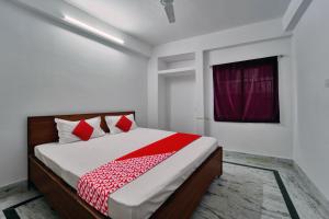 a bedroom with a bed with red and white sheets at Super OYO Flagship Hotel Mahal Inn in Patna