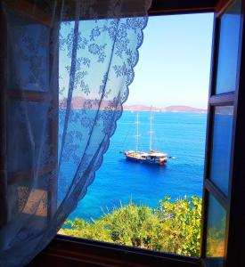 a window view of a sail boat in the water at Patmos Garden Sea in Grikos