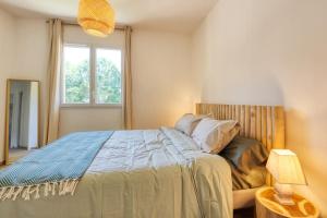 a bedroom with a large bed and a window at Résidence Escale Bleue in Andernos-les-Bains