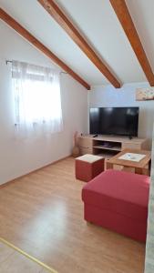 a living room with a red couch and a flat screen tv at Apartment Ankica in Umag