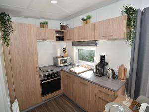 a small kitchen with wooden cabinets and a microwave at Holiday Home Seeperle by Interhome in Wemding