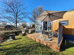 a wooden deck with a table and an umbrella at Holiday Home Seeperle by Interhome in Wemding