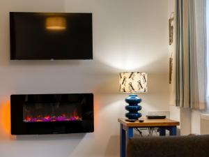 a living room with a fireplace and a tv on the wall at Holiday Home Marshmallow House by Interhome in St Austell +33 photos