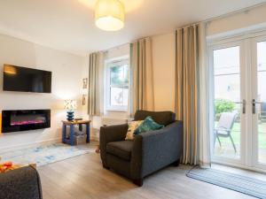 a living room with a chair and a tv at Holiday Home Marshmallow House by Interhome in St Austell