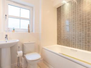 a bathroom with a toilet and a tub and a sink at Holiday Home Marshmallow House by Interhome in St Austell