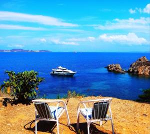 GrikosにあるPatmos Garden Seaのビーチでのボート付き椅子2脚