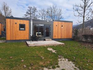 a house with wooden panels on the side of a yard at Holiday Home Tiny Haus Altmühlblick III by Interhome in Riedenburg