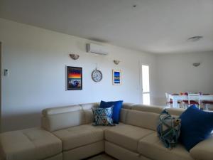 sala de estar con sofá marrón con almohadas azules en Villa Lu Tizzoni, en Budoni