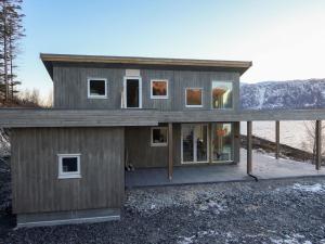 une maison sur une colline avec des montagnes en arrière-plan dans l'établissement Holiday Home Hildebu - FJS156 by Interhome, à Sørbø