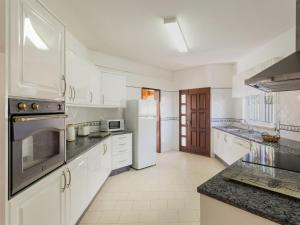 eine Küche mit weißen Schränken und einem Kühlschrank in der Unterkunft Holiday Home Paulo by Interhome in Galé
