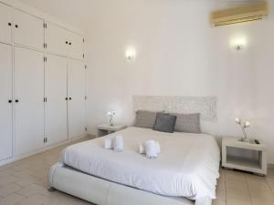 ein weißes Schlafzimmer mit einem großen weißen Bett und zwei Handtüchern in der Unterkunft Holiday Home Paulo by Interhome in Galé