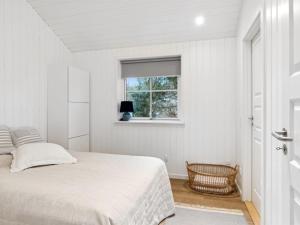 a white bedroom with a bed and a window at Holiday Home Loviisa - 850m from the sea by Interhome in Gilleleje