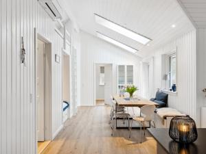 a white living room with a table and a couch at Holiday Home Loviisa - 850m from the sea by Interhome in Gilleleje