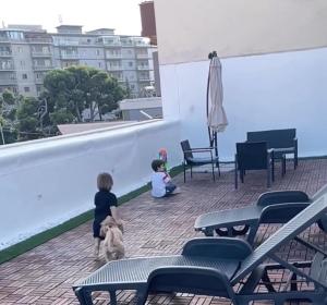 duas crianças e um cão no telhado de um edifício em Terrazze Alelà apartment em Bari