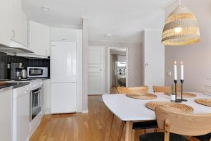 cocina y comedor con mesa blanca y sillas en Guestly Homes - 1BR Cozy Apartment en Boden