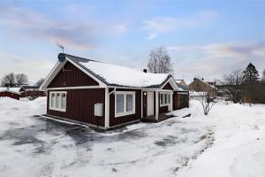 une maison recouverte de neige dans une cour dans l'établissement Guestly Homes - 1BR Cozy Apartment, à Boden