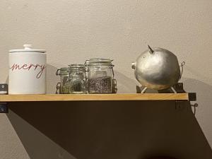 a shelf with jars and a pot and an apple at Holiday Home Wieliczka by Interhome in Wieliczka