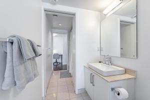 een witte badkamer met een wastafel en een spiegel bij Downtown Apartments (5) in Toronto