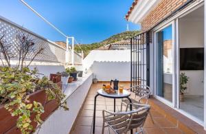 a patio with a table and chairs on a balcony at Casa con piscina comunitaria en Albayzin alto in Granada