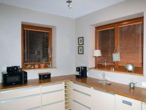 a kitchen with two windows and a wooden counter top at Holiday Home Wieliczka by Interhome in Wieliczka