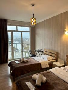 a hotel room with two beds and a large window at Hotel Marioni in Tbilisi City