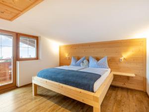 una camera con un grande letto con testiera in legno di Apartment Hocheben by Interhome a Ramsau im Zillertal
