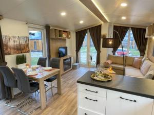 eine Wohnwagen-Küche und ein Wohnzimmer mit einem Tisch und Stühlen in der Unterkunft Holiday Home Tiny Haus Franzl by Interhome in Riedenburg