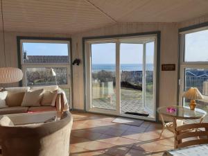 Sala de estar con sofá y vistas al océano en Holiday Home Gerlak - 150m from the sea in SE Jutland by Interhome, en Binderup Strand