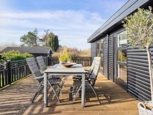 a patio with a table and chairs on a deck at Holiday Home Arlina - 750m from the sea in Sealand by Interhome in Fårevejle