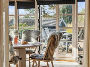 a porch with a table and chairs and a patio door at Holiday Home Arlina - 750m from the sea in Sealand by Interhome in Fårevejle