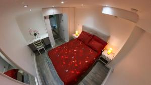 a bedroom with a red bed with red sheets at 1 Bedroom Flat with whirlpool bath in London