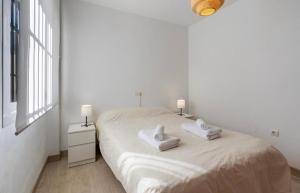 a white bedroom with a bed with towels on it at Casa con piscina comunitaria en Albayzin alto in Granada +12 photos