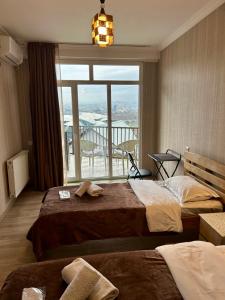 a hotel room with two beds and a large window at Hotel Marioni in Tbilisi City