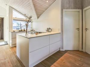 uma cozinha com armários brancos e uma grande janela em Holiday Home Ubbe - 800m from the sea in Western Jutland by Interhome em Fanø