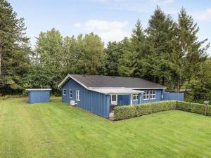 un cobertizo azul en un patio con césped grande en Holiday Home Marlina - 30km from the sea in Western Jutland by Interhome, en Toftlund