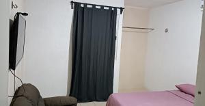 ein Schlafzimmer mit einem Bett und einem schwarzen Vorhang in der Unterkunft alojamiento económico in Mérida