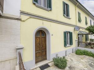 un edificio giallo con una porta in legno di Holiday Home Il Cortile by Interhome a Follonica