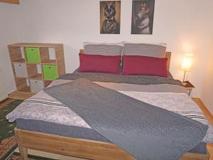 a bedroom with a bed with two red pillows at Apartment Sandra Falch by Interhome in Flirsch