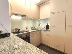 a kitchen with white cabinets and a counter top at Studio Haus Arabelle by Interhome in Davos