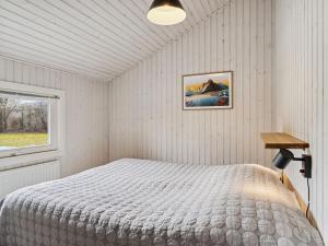 1 dormitorio con cama y ventana en Holiday Home Ajvi - 900m from the sea in Sealand by Interhome, en Dronningmølle