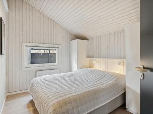 Habitación blanca con cama y ventana en Holiday Home Ajvi - 900m from the sea in Sealand by Interhome, en Dronningmølle
