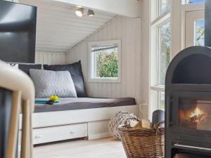 1 cama en una casa pequeña con chimenea en Holiday Home Ajvi - 900m from the sea in Sealand by Interhome, en Dronningmølle