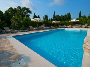 a swimming pool with chairs and umbrellas at Villa Mega by Interhome in Barban