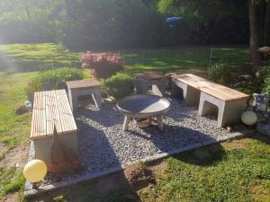 a barbecue grill and benches in a yard at Apartment Am Hohen Bogen-75 by Interhome in Kummersdorf