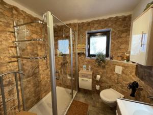 a bathroom with a shower and a toilet and a sink at Apartment Am Hohen Bogen-75 by Interhome in Kummersdorf