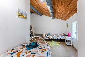 1 dormitorio con 2 camas y techo de madera en Chez Lea, en Saint-Seurin-de-Cadourne